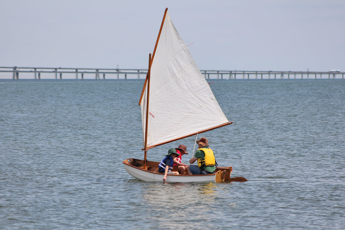 Dad and his two children enjoying an Eastport Nesting Pram at Okoumefest.