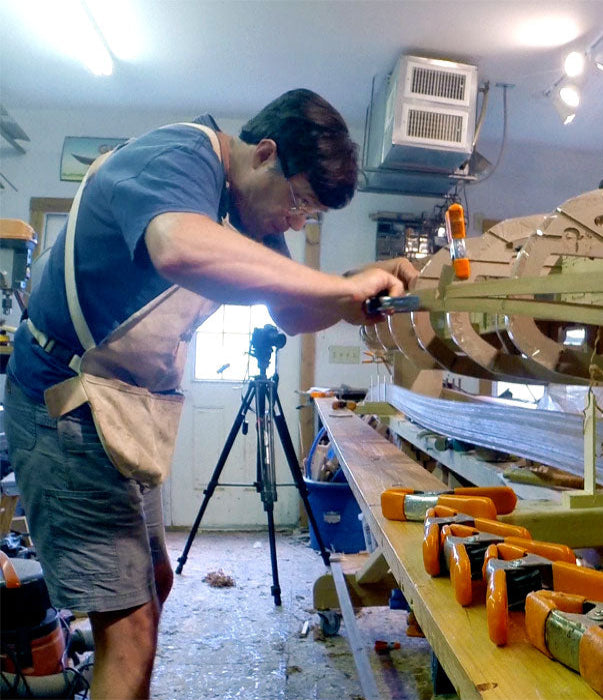 Designer Nick Schade stapling the first strips onto a Petrel Play kayak.