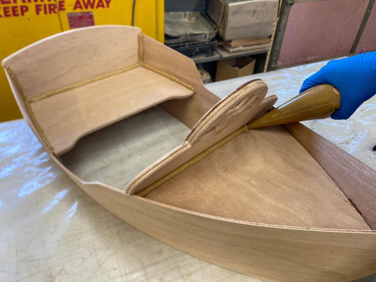 Applying epoxy fillets to enhance the bond of the wood parts.
