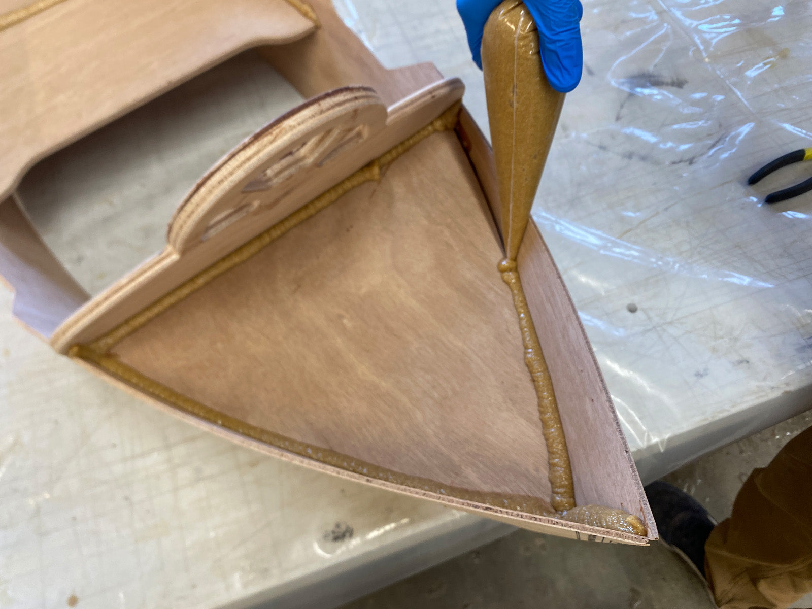 Applying epoxy fillets to enhance the bond of the wood parts.