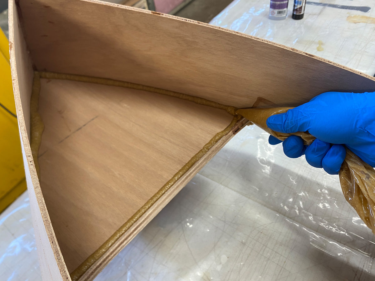 Applying epoxy fillets to enhance the bond of the wood parts.