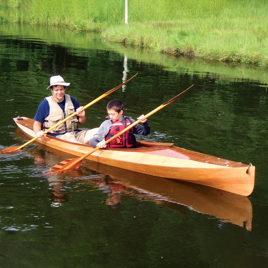 A man and a boy paddling a Wood Duck Double kayak